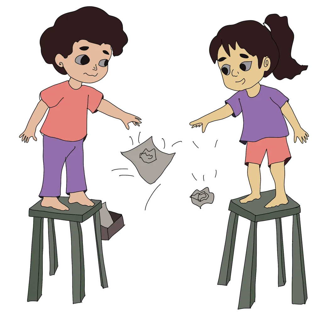 A child dropping flat paper against crumpled paper to compare how air slows them